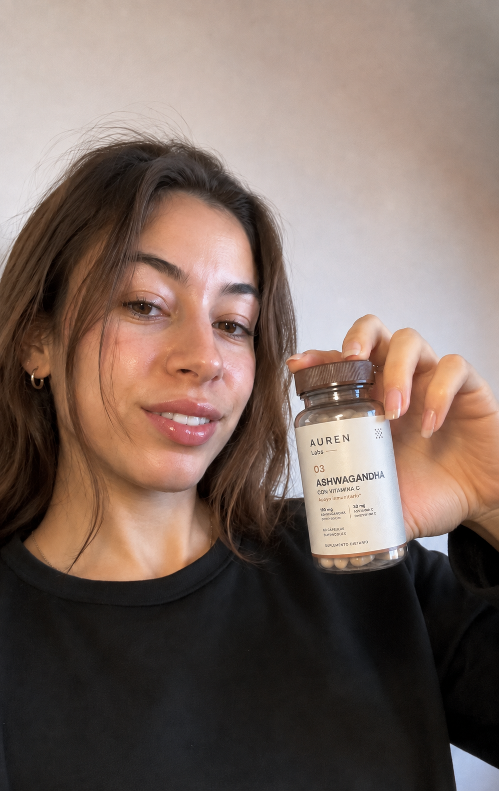 AUREN customer holding an Ashwagandha bottle at home